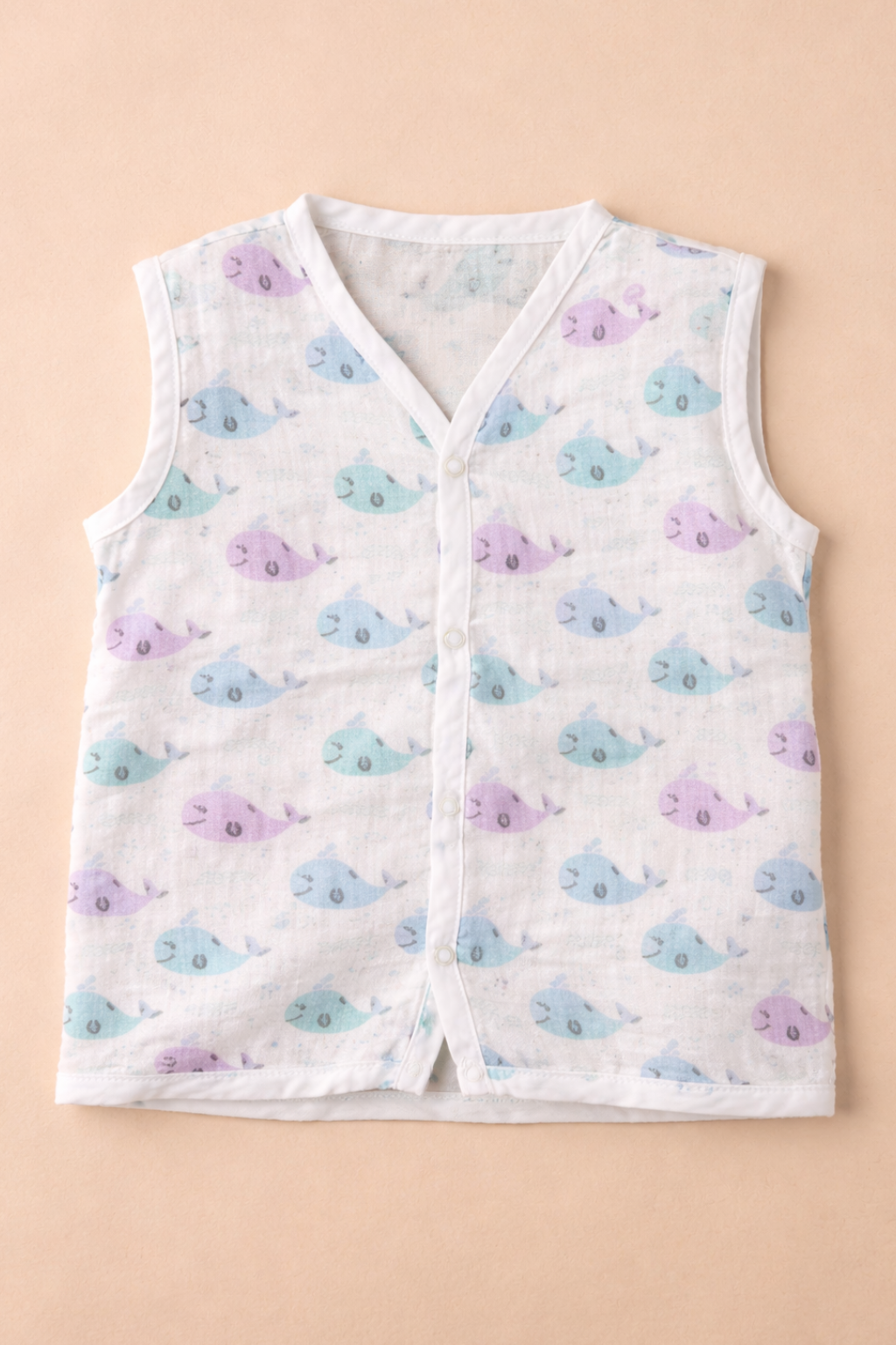 Baby vest with whale pattern on a beige background